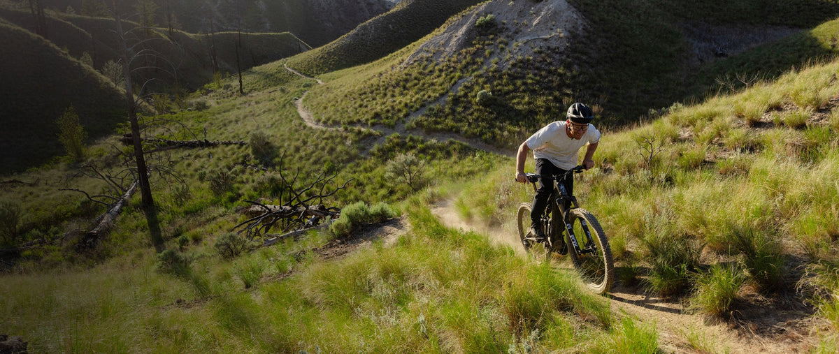 Rider on a Specialized Turbo Levo on grassy singletrack