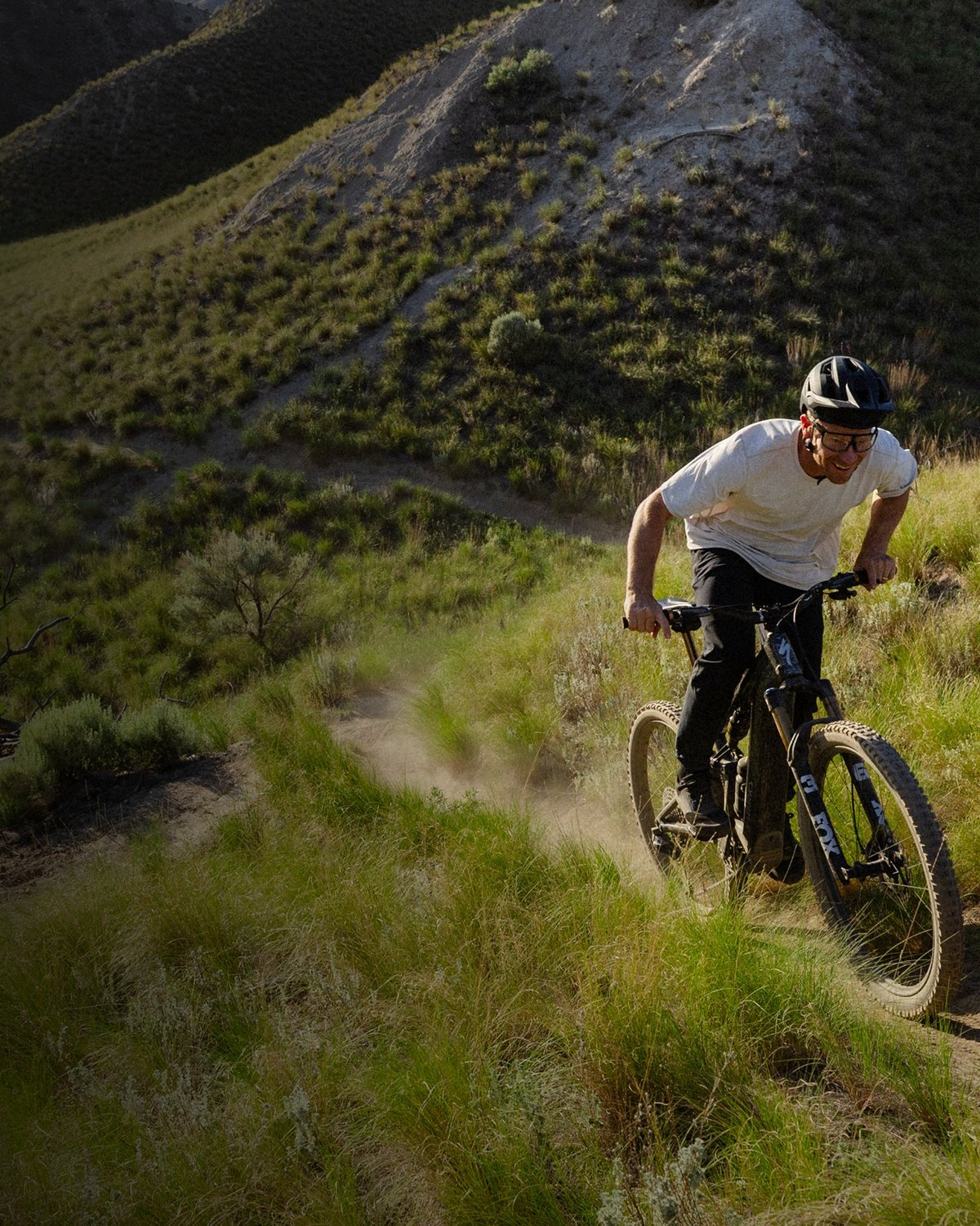 Rider on a Specialized Turbo Levo on grassy singletrack